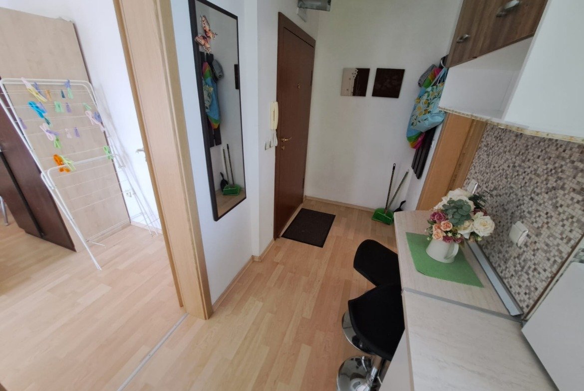 Двухкомнатный апартамент в Болгарии с уютной прихожей, кухней и зоной для отдыха. Светлые тона и современный дизайн.