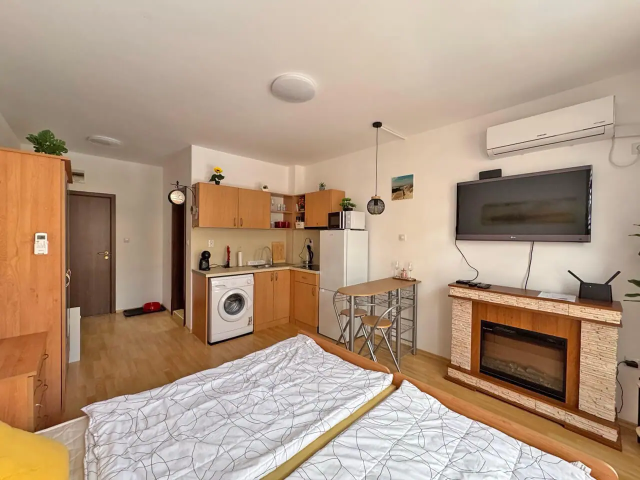 Уютная студия с кухней, обеденной зоной, стиральной машиной и обогревателем в комплексе Sunny Day 6. Светлые тона и современный интерьер.