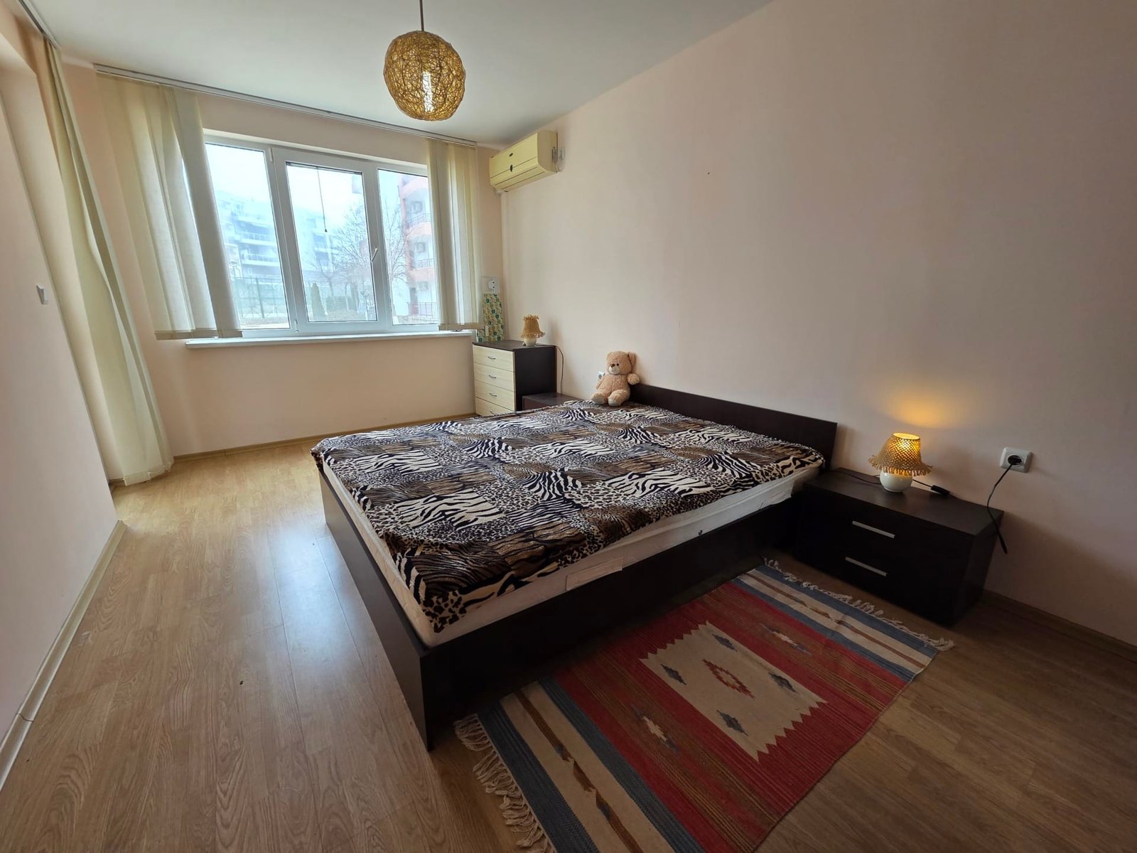 Двухкомнатный апартамент с уютной спальней в Riviera Fort Beach Двухкомнатный апартамент с ванной в комплексе Riviera Fort Beach, светлая спальня с кроватью и тёплыми тонами.