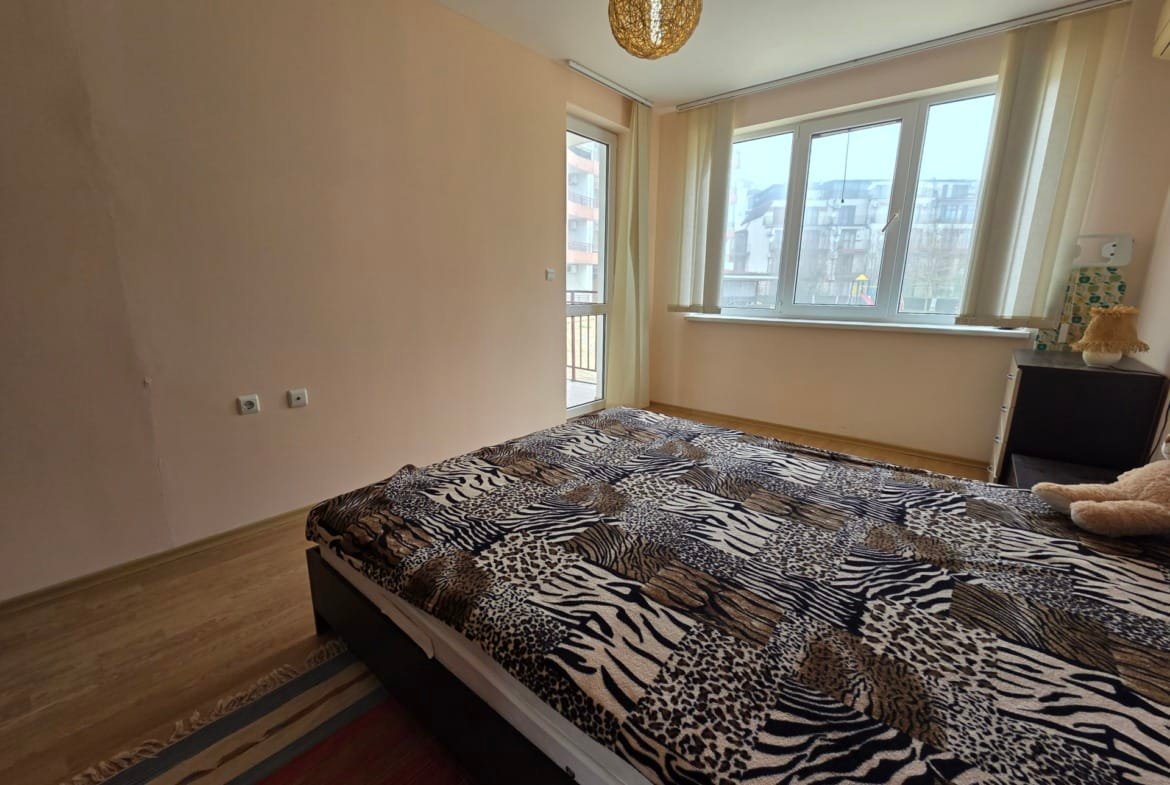 Современная спальня с двуспальной кроватью, светлыми стенами, панорамными окнами и стильным освещением.