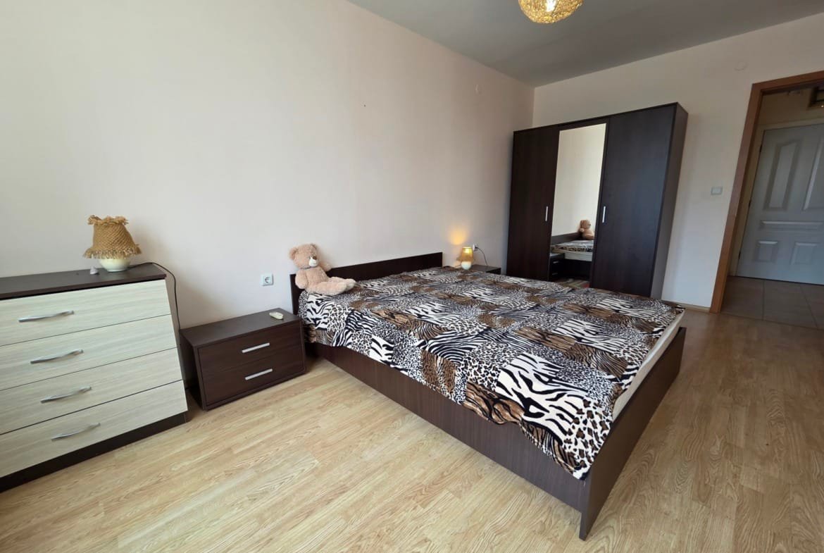 Современная спальня с двуспальной кроватью, комодом и платяным шкафом, оформленная в светлых тонах и стильным текстилем.