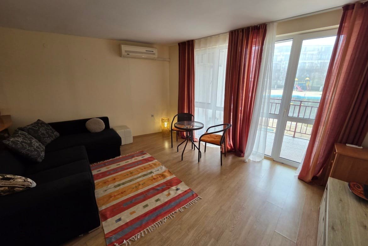 Двухкомнатный апартамент с мягкой мебелью, обеденным столом и выходом на балкон с видом на бассейн в Riviera Fort Beach.