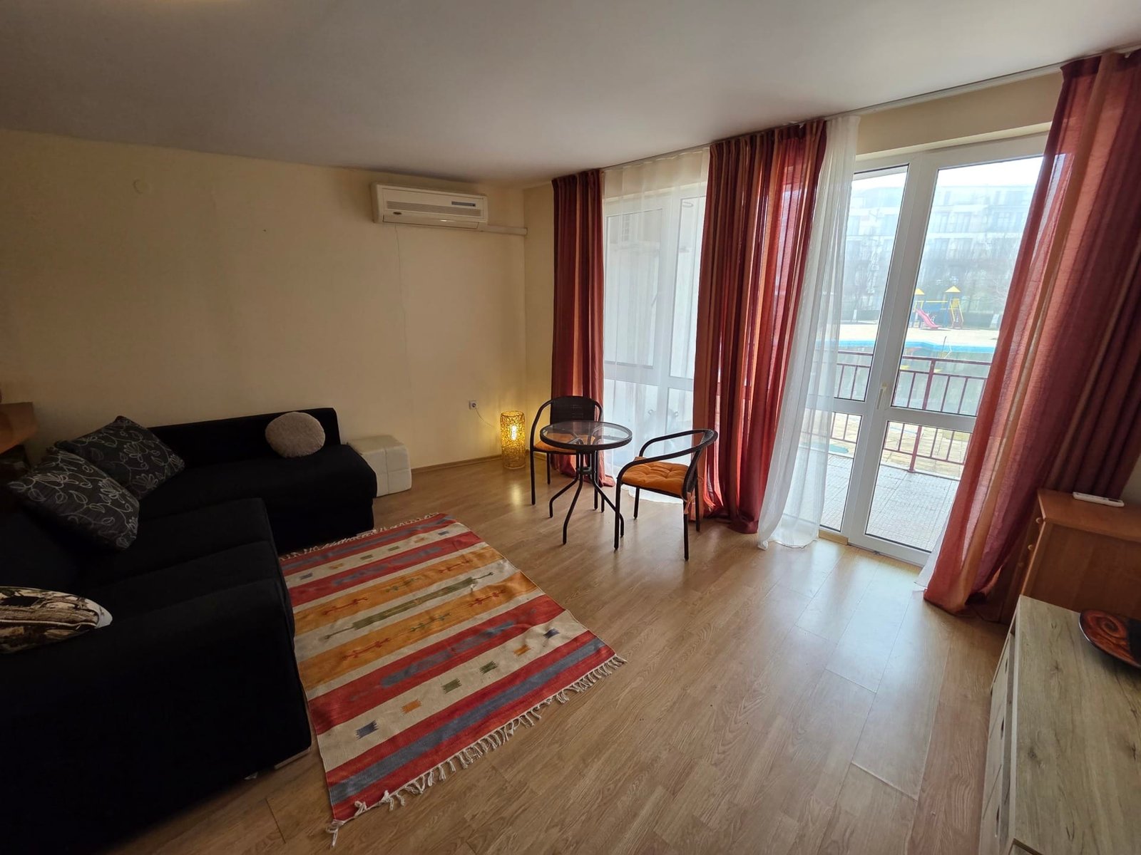 Двухкомнатный апартамент с видом на бассейн в Riviera Fort Beach Двухкомнатный апартамент с мягкой мебелью, обеденным столом и выходом на балкон с видом на бассейн в Riviera Fort Beach.