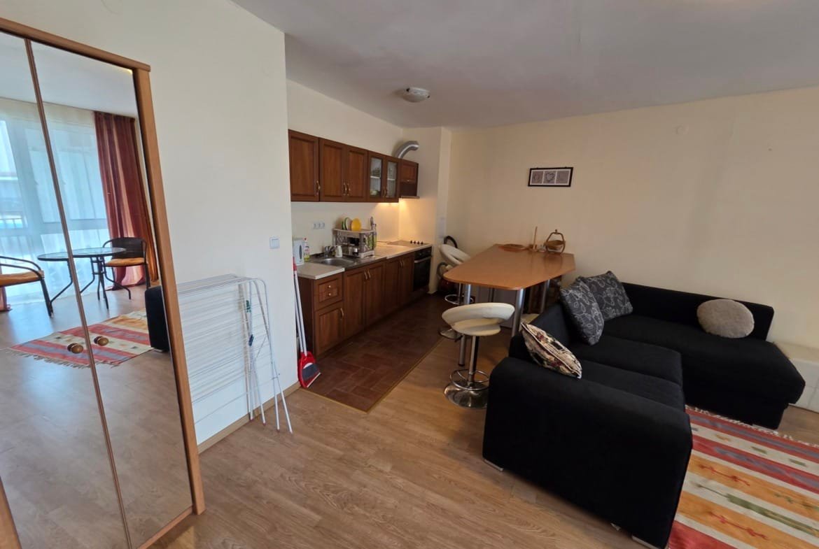 Современный двухкомнатный апартамент с кухней, обеденной зоной и уютной гостиной, оформленный в светлых тонах.