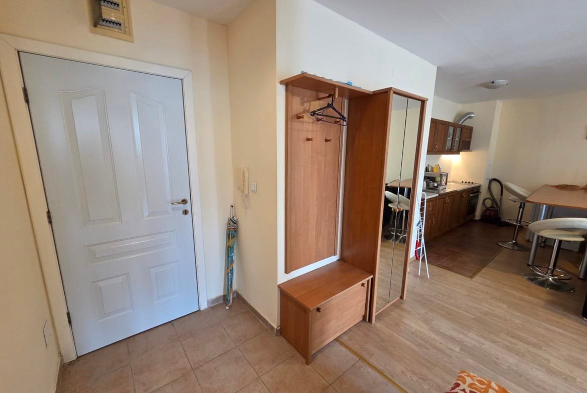 Современный интерьер двухкомнатного апартамента: прихожая с шкафом и кухонная зона с барной стойкой.