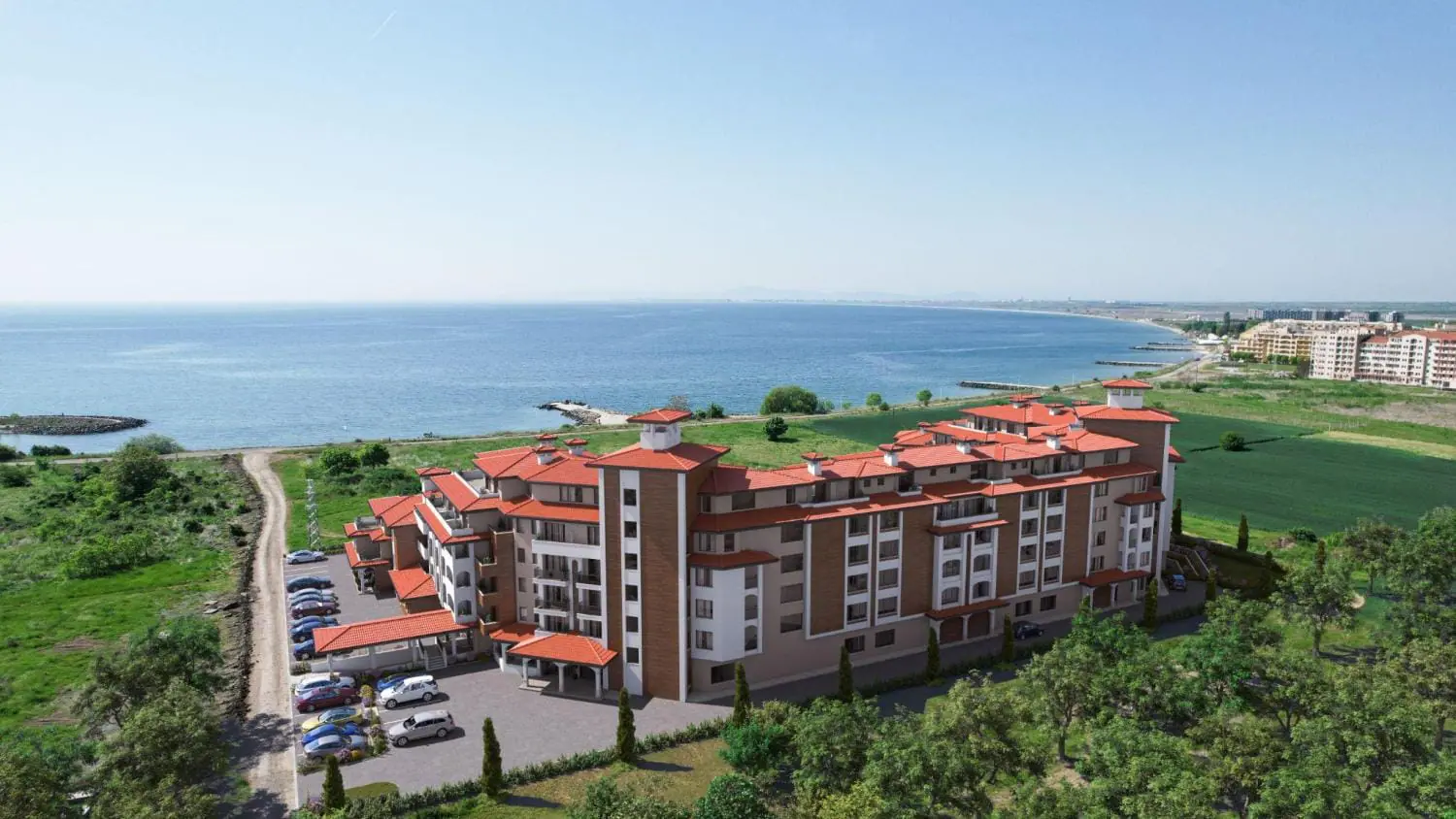 Новый жилой комплекс “SOLEMARE BY THE SEA” у моря Новый жилой комплекс у моря с современными зданиями, зелеными насаждениями и автопарковкой на фоне пляжа.