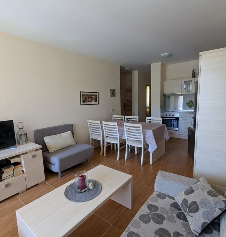 Современный интерьер трехкомнатного апартамента: светлая гостиная с диваном, столовая зона и кухня в стиле минимализм.