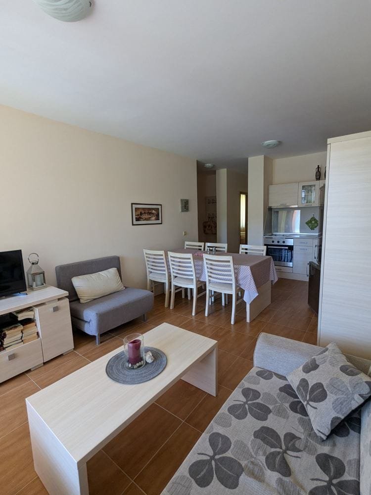 Современный интерьер трехкомнатного апартамента: светлая гостиная с диваном, столовая зона и кухня в стиле минимализм.