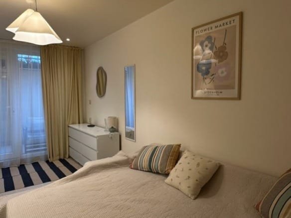 Современная студия с мягким угловым диваном, светлыми тонами, минималистичной мебелью и уюта создающим освещением.