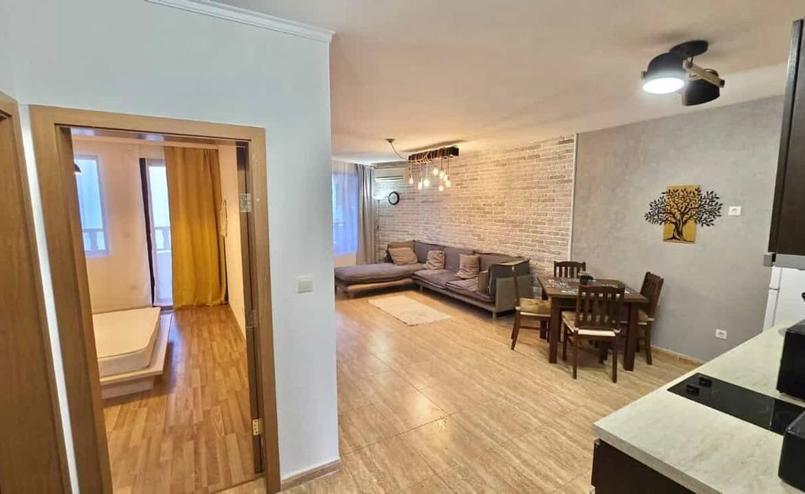 Современная двухкомнатная квартира с открытой планировкой, светлой гостиной, кухней и пастельными цветами интерьера.