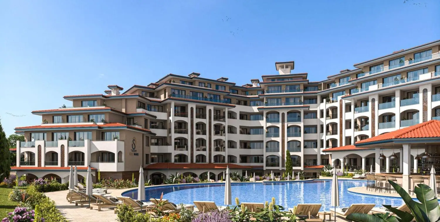 Жилой комплекс Solemare: роскошные апартаменты у моря Современный жилой комплекс с бассейном, террасами и зелеными насаждениями на фоне ясного неба.