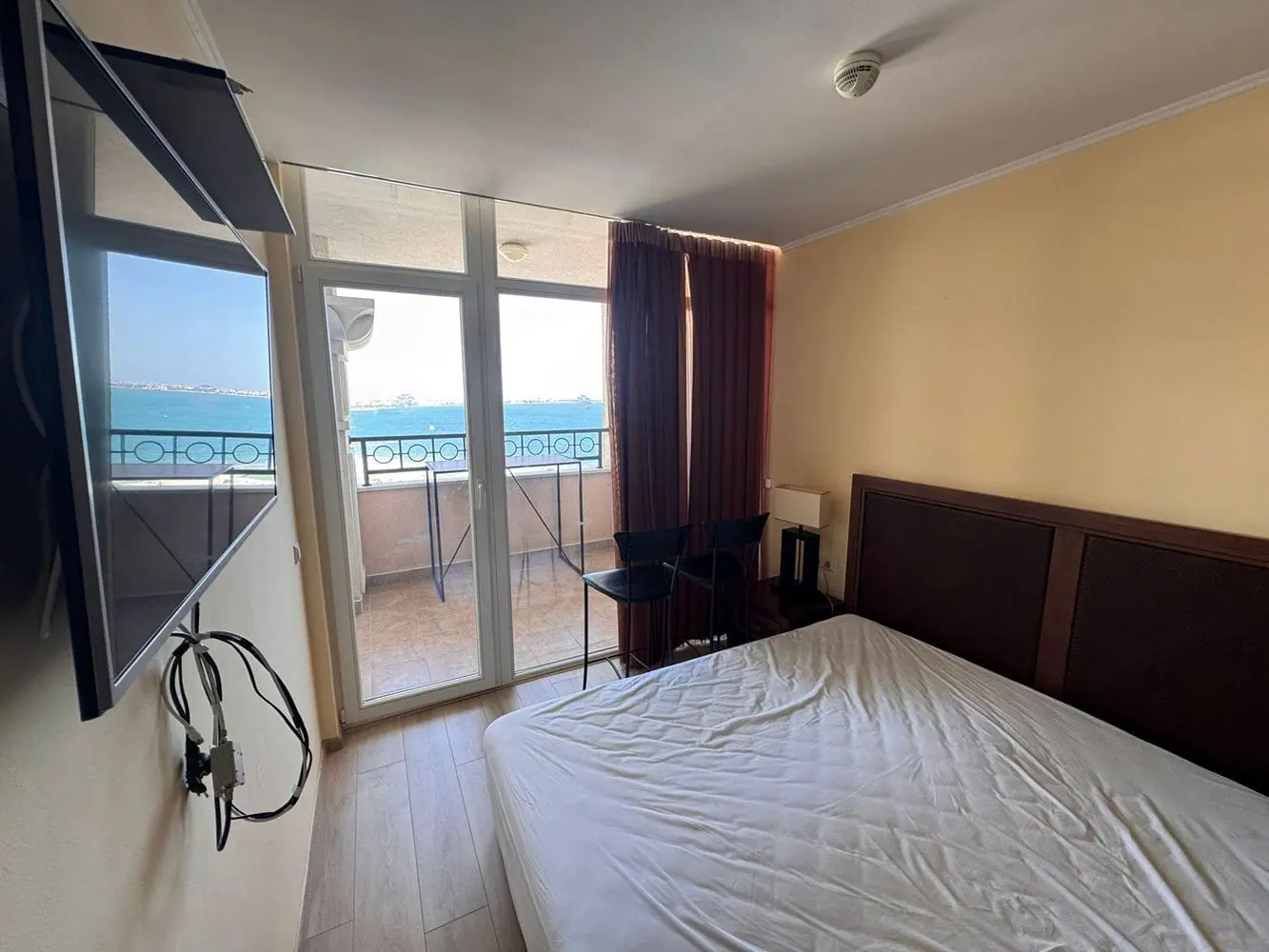Трехкомнатный апартамент в Sunset Resort с балконом и видом на море Современный интерьер трехкомнатного апартамента с балконом, видом на море и телевизором на стене.