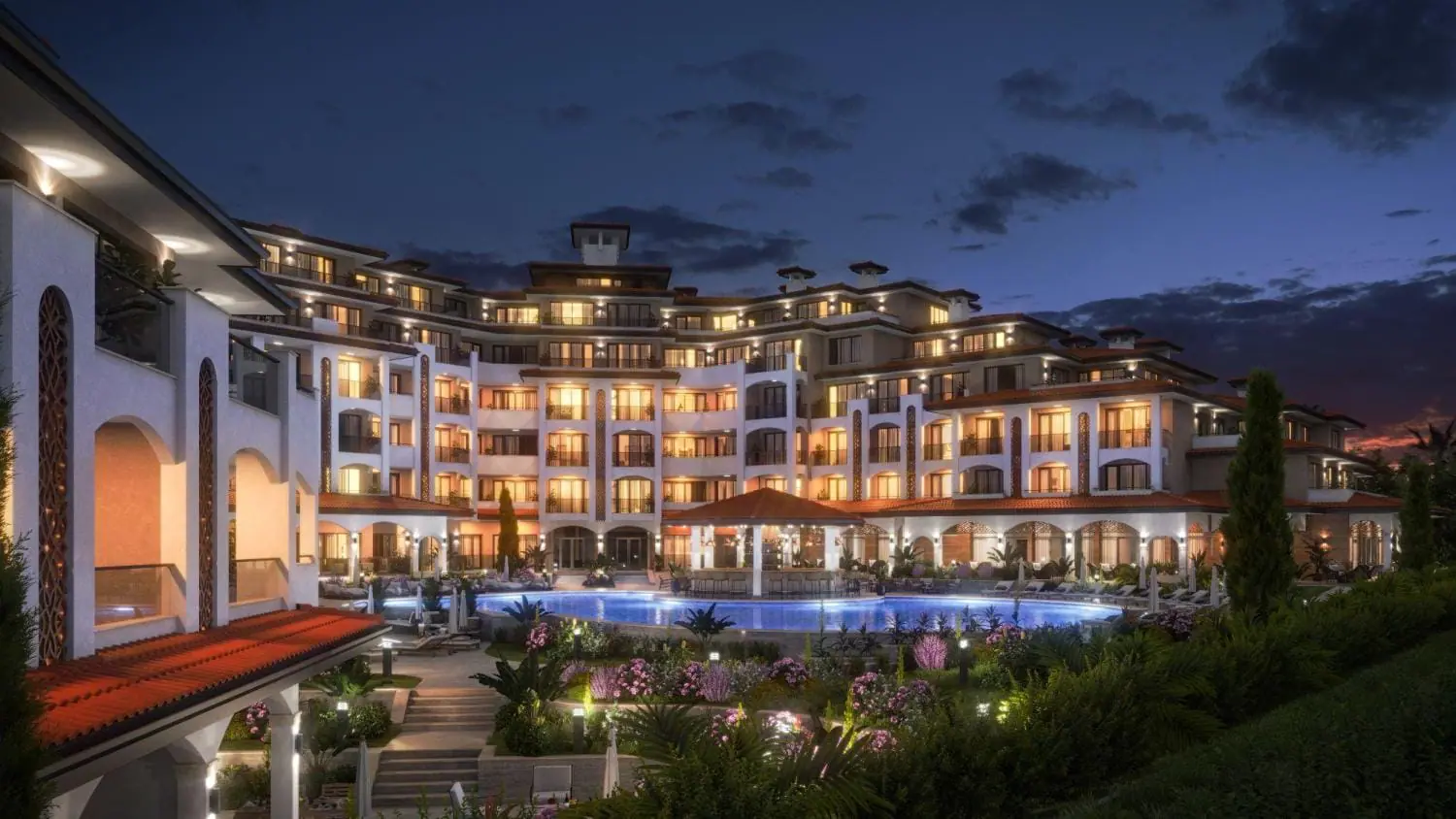 Новый жилой комплекс “SOLEMARE BY THE SEA” у моря в вечернее время Ночной вид на жилой комплекс с террасами, бассейном и ухоженным садом, освещённый уютными огнями.