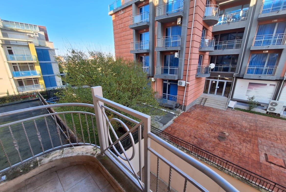 Балкон двухкомнатного апартамента с видом на зеленый двор и соседние здания в комплексе Sea Regal.