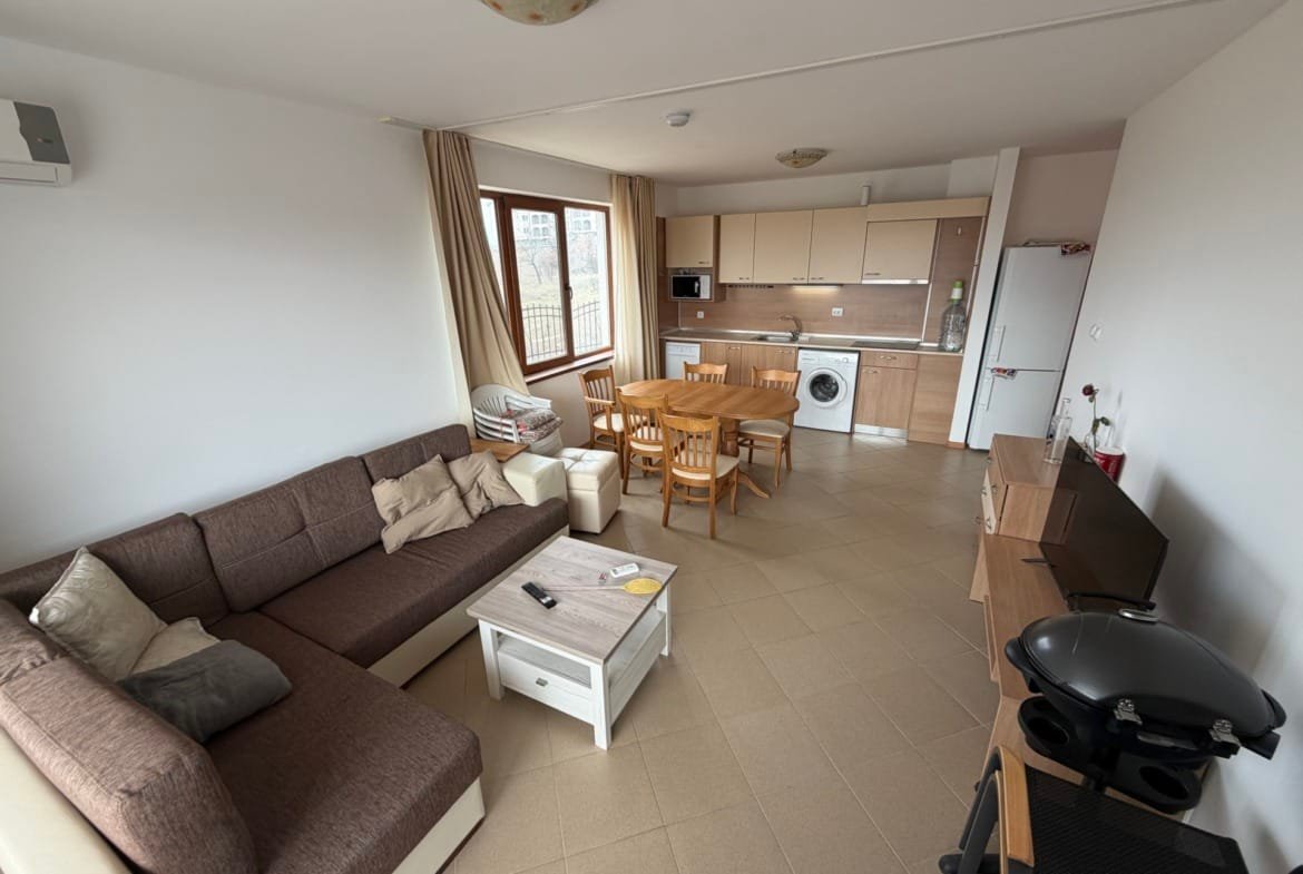 Современный интерьер трехкомнатного апартамента с кухней, обеденным зоной и диваном, светлые тона и удобная планировка.