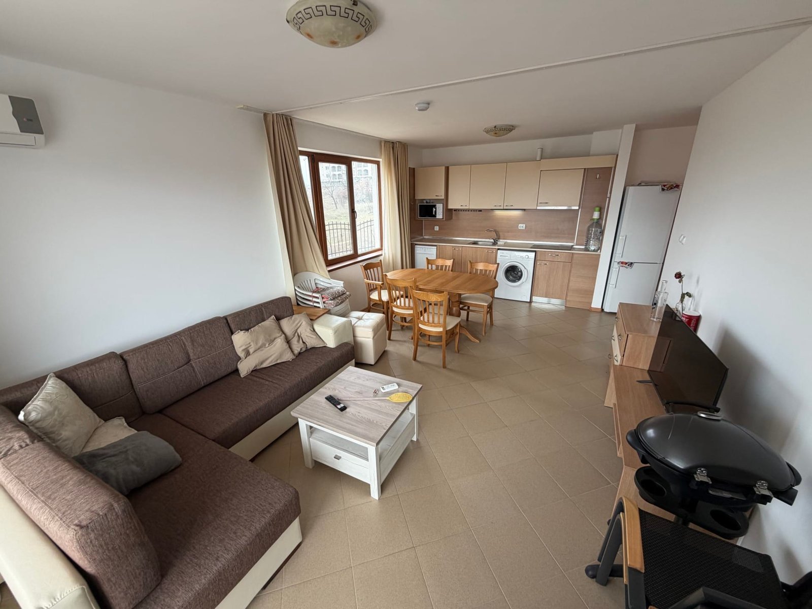 Современный интерьер трехкомнатного апартамента с кухней, обеденным зоной и диваном, светлые тона и удобная планировка.