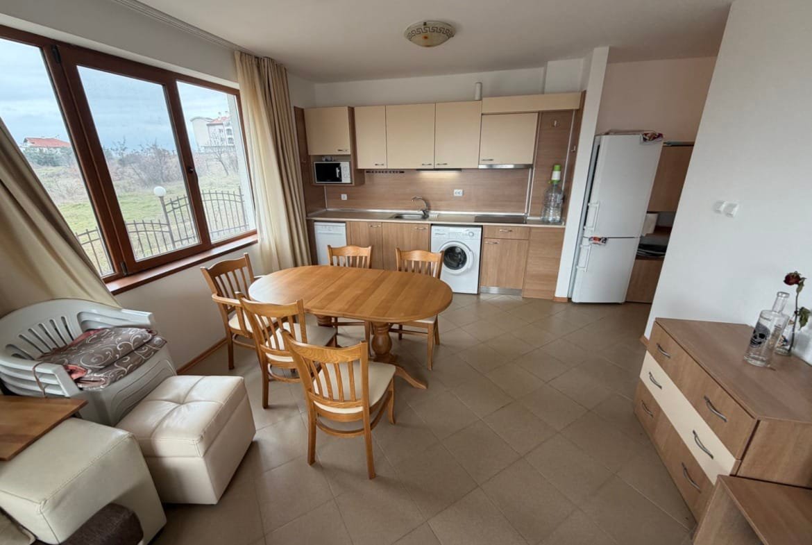 Современный трехкомнатный апартамент с кухней, обеденным столом, стиральной машиной и большими окнами с видом на природу.