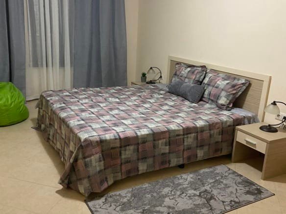 Двухкомнатный апартамент с кроватью, столиком, ковром и уютным занавесом в комплексе Royal Sun.