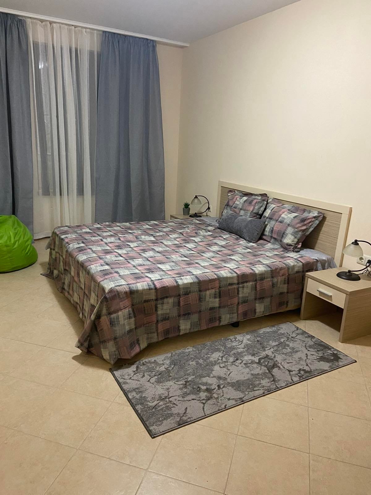 Двухкомнатный апартамент с кроватью, столиком, ковром и уютным занавесом в комплексе Royal Sun.