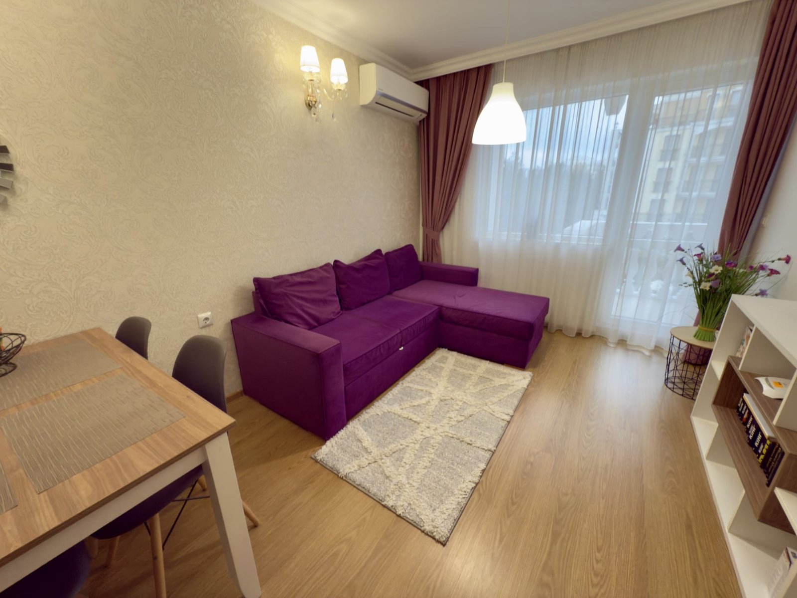 Современный интерьер трехкомнатного апартамента с фиолетовым диваном, светлом и стильной мебелью.