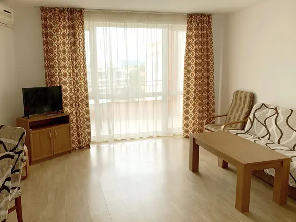 Современный светлый двухкомнатный апартамент с мебелью, телевизором и большими окнами, выходящими на балкон.