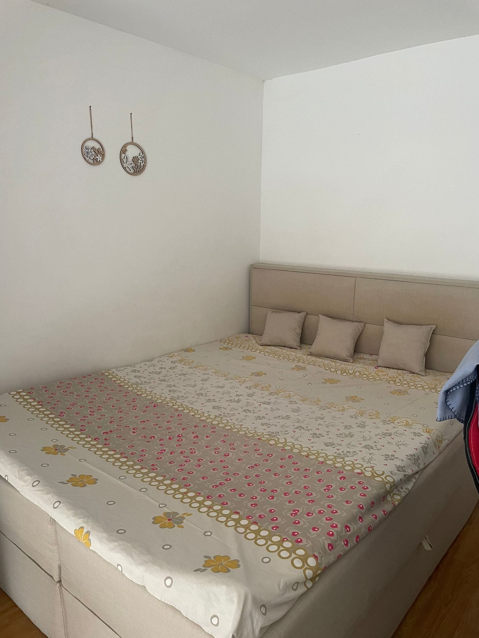 Современная спальня с двуспальной кроватью, украшенной текстильным покрывалом и декоративными подушками. Светлые тона стен.