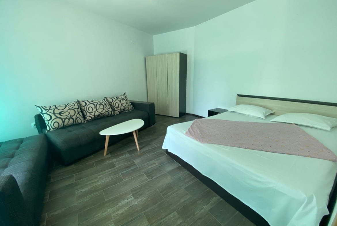 Трехкомнатный апартамент с кроватью, зоной отдыха и мягкой мебелью, светлые тона и современный дизайн интерьера.