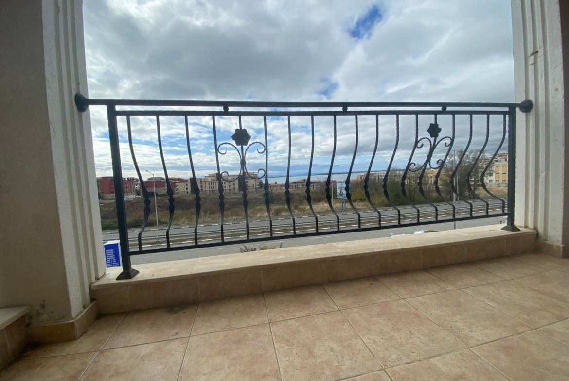 Балкон с металлическим ограждением, панорамный вид на город и небо, плитка на полу. Подходит для жилья в комплексе Macon Residence.