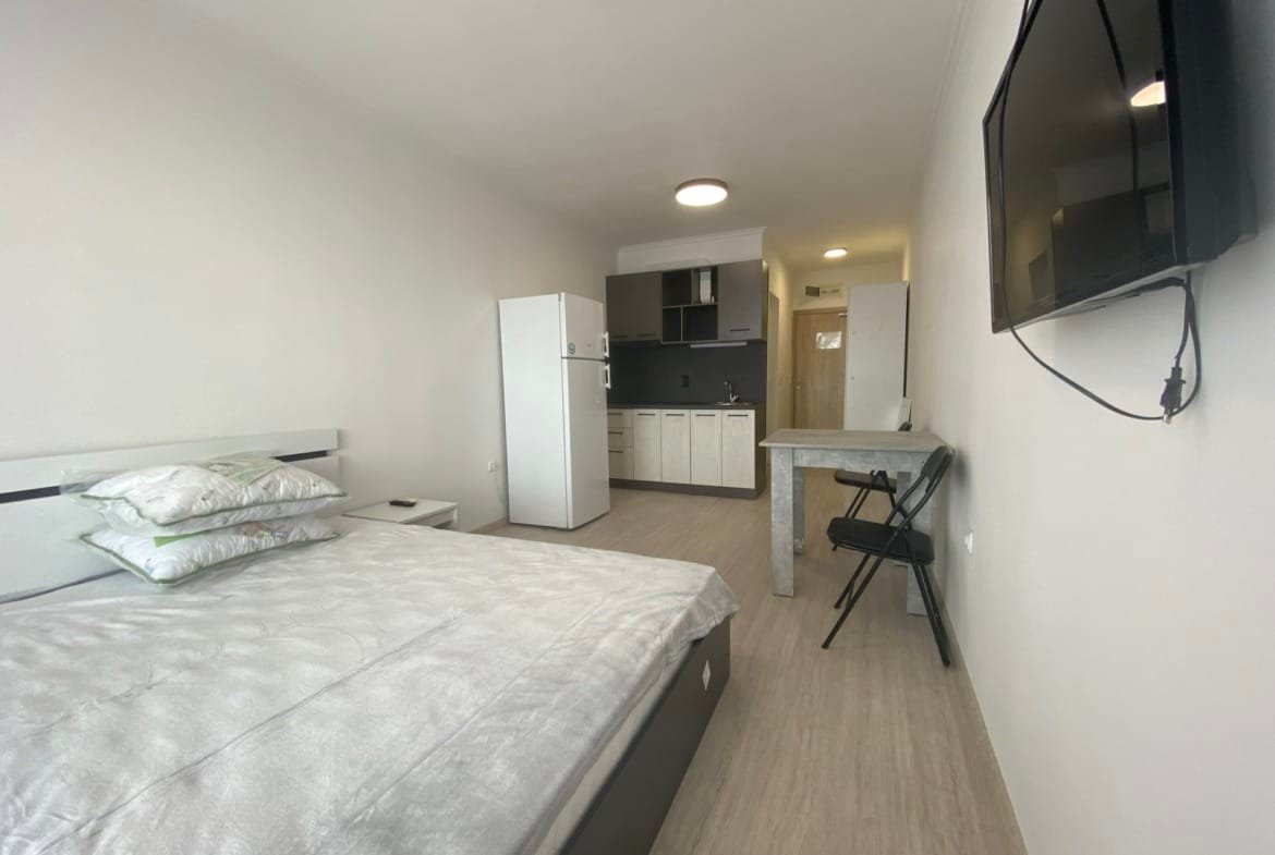 Современная студия с двуспальной кроватью, кухней, стиральной машинкой и телевизором в комплексе Macon Residence.