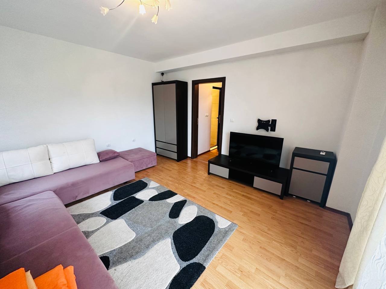 Современный интерьер трехкомнатного апартамента с диваном, телевизором и светлымиWalls. Комфортное и стильное пространство для проживания.