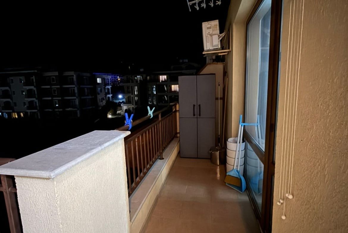 Уютный балкон с окнами, шкафом и чистым полом, атмосфера спокойной ночи с мягким освещением.