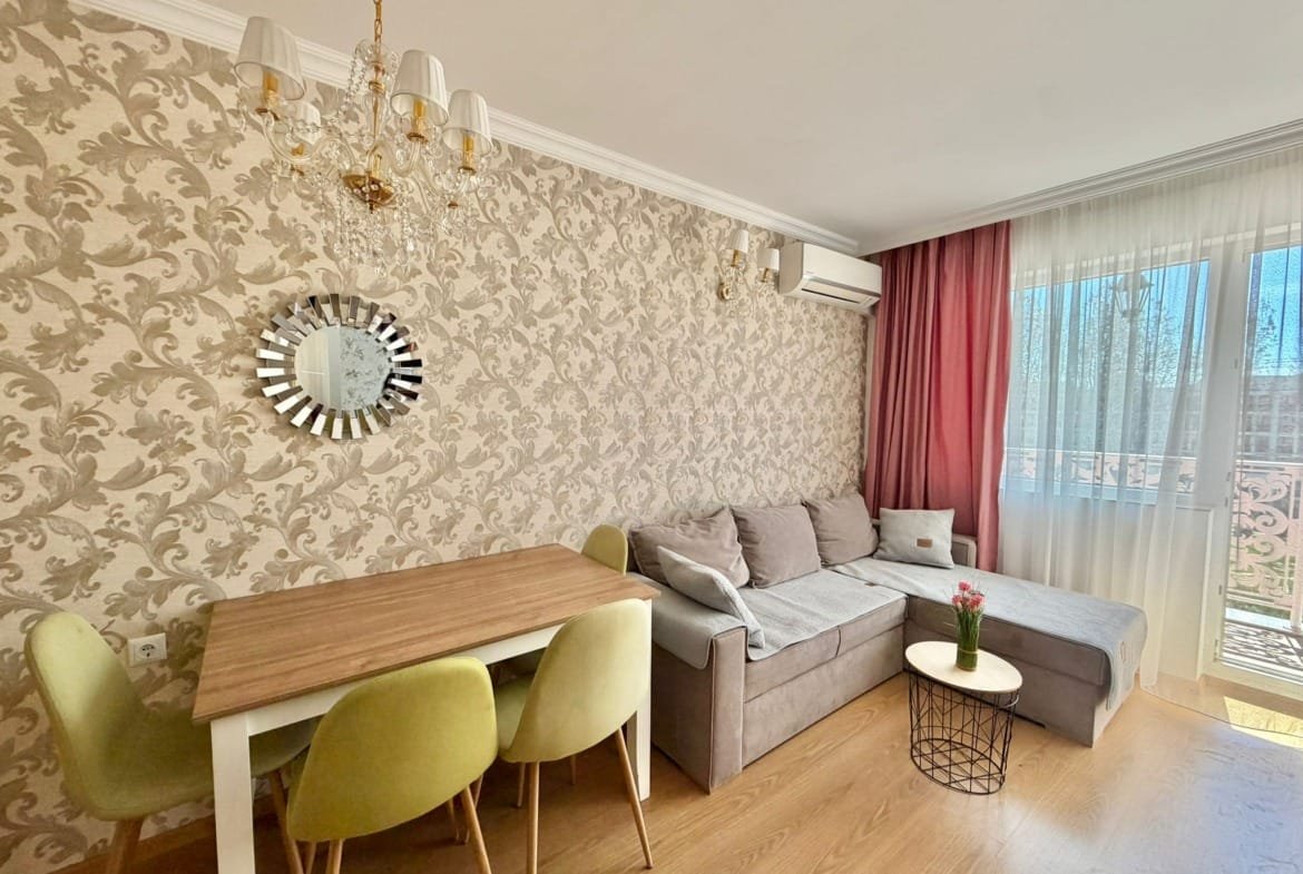 Современная гостиная с диваном, обеденным столом и стульями, оформленная в светлых тонах, идеальная для покупки недвижимости в Болгарии.