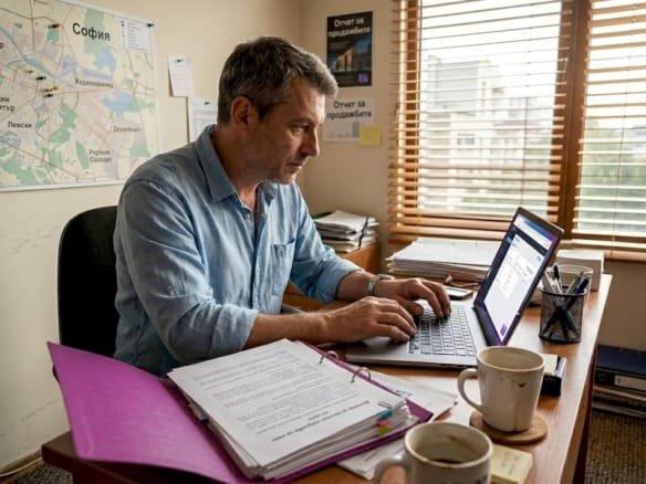 Мужчина внимательно изучает договор на покупку недвижимости в Болгарии.