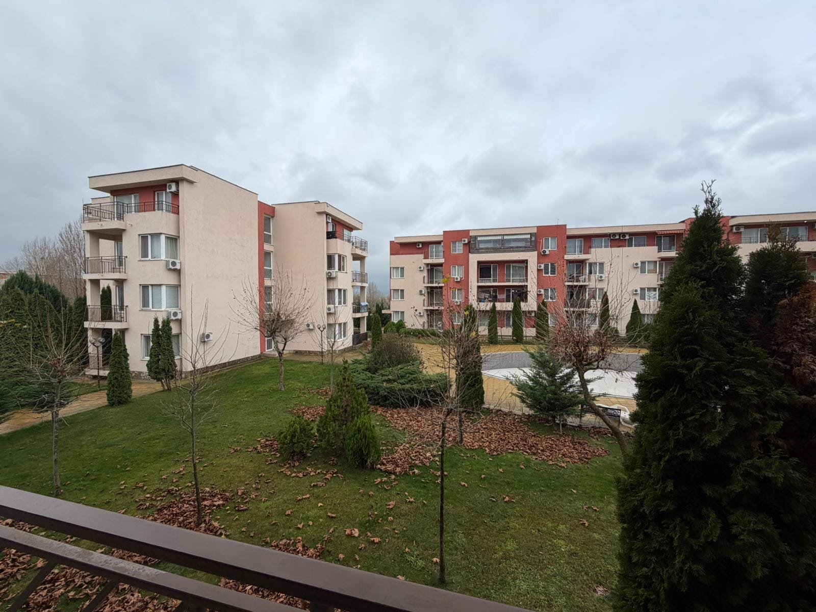 Современные жилые комплексы с зелеными насаждениями и облачным небом Современные жилые комплексы в Болгарии с зелеными насаждениями и благоустроенной территорией для комфортного проживания.