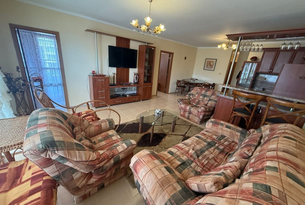 Уютная гостиная с красочными креслами, телеком и кухонным баром, подходит для продажи недвижимости в Болгарии.