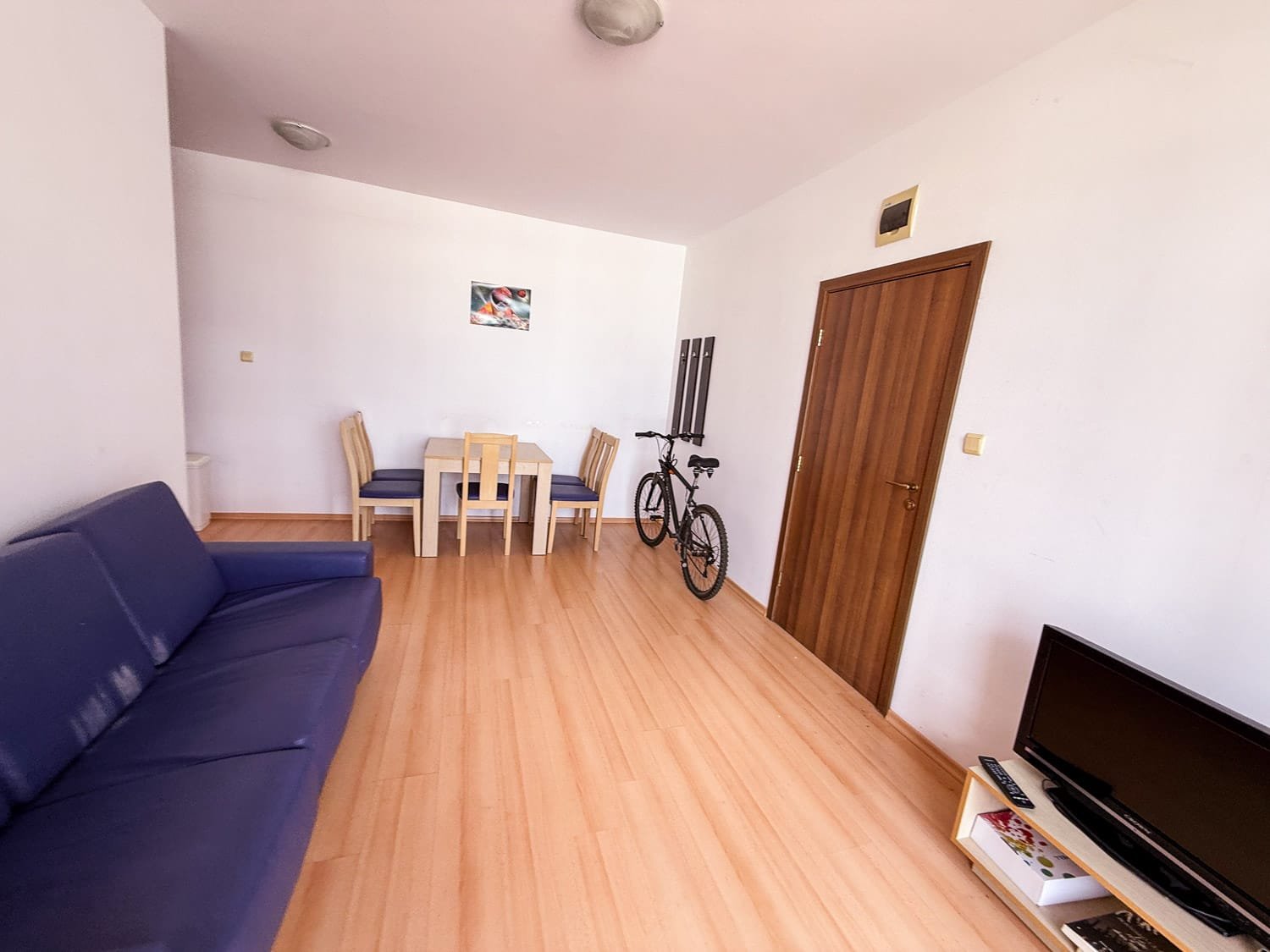 Современная квартира в Болгарии с гостиной, столовой, велосипедами и мягкой мебелью, идеальная для покупки или аренды.