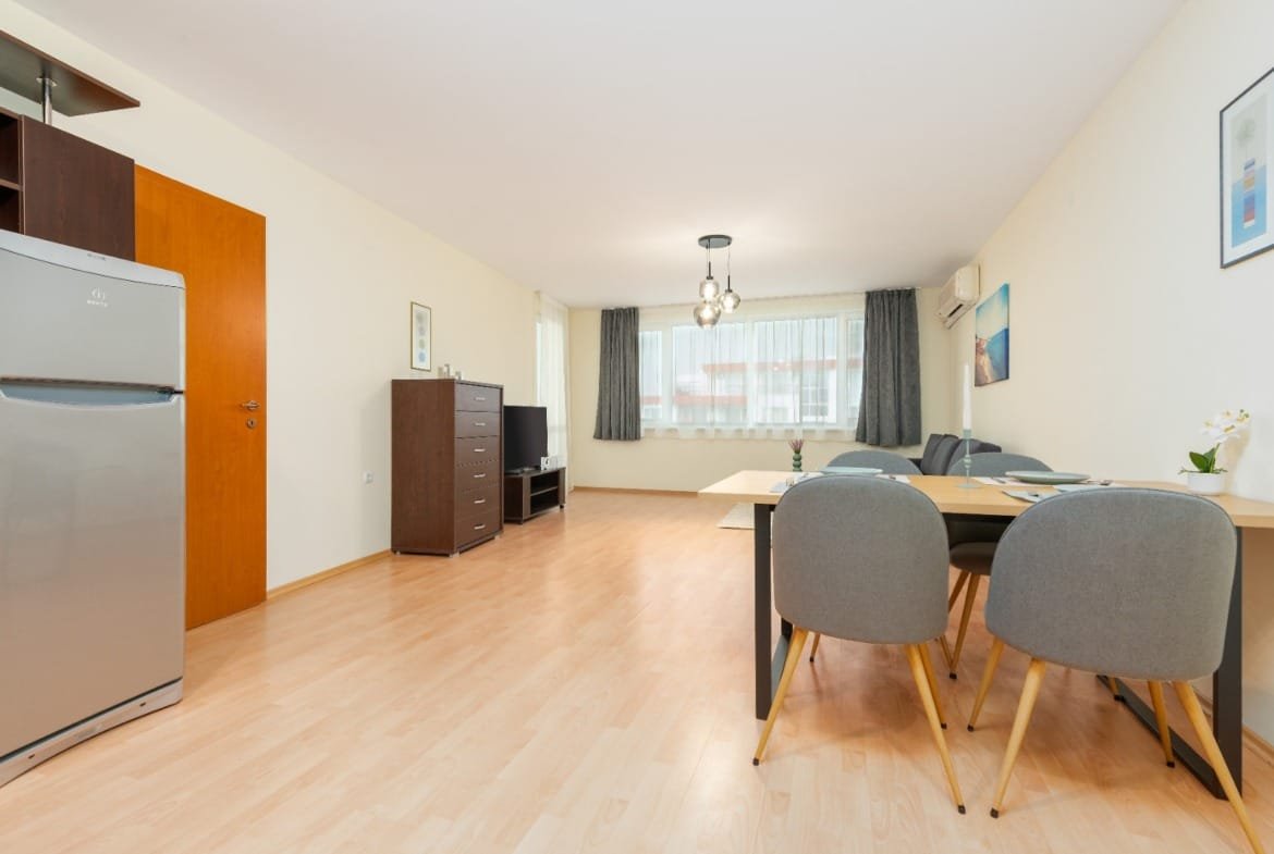 Современная квартира в Болгарии с открытой планировкой, светлым интерьером и меблированной гостиной для комфортной жизни.