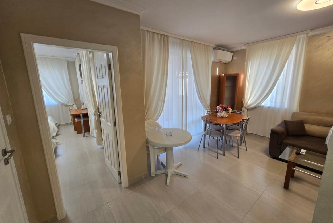 Современная квартира в Болгарии с мягкими тонами, светлым интерьером, столом для обедов и удобной зоной для отдыха.