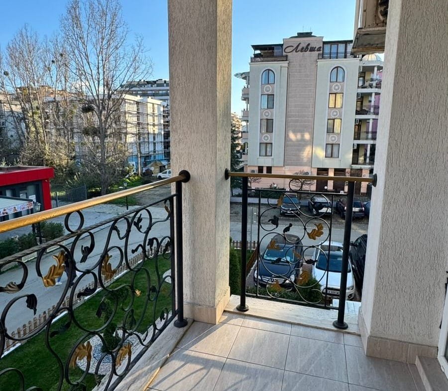 Балкон с металлическим ограждением, вид на улицу и здания, идеальное место для продажи недвижимости в Болгарии.