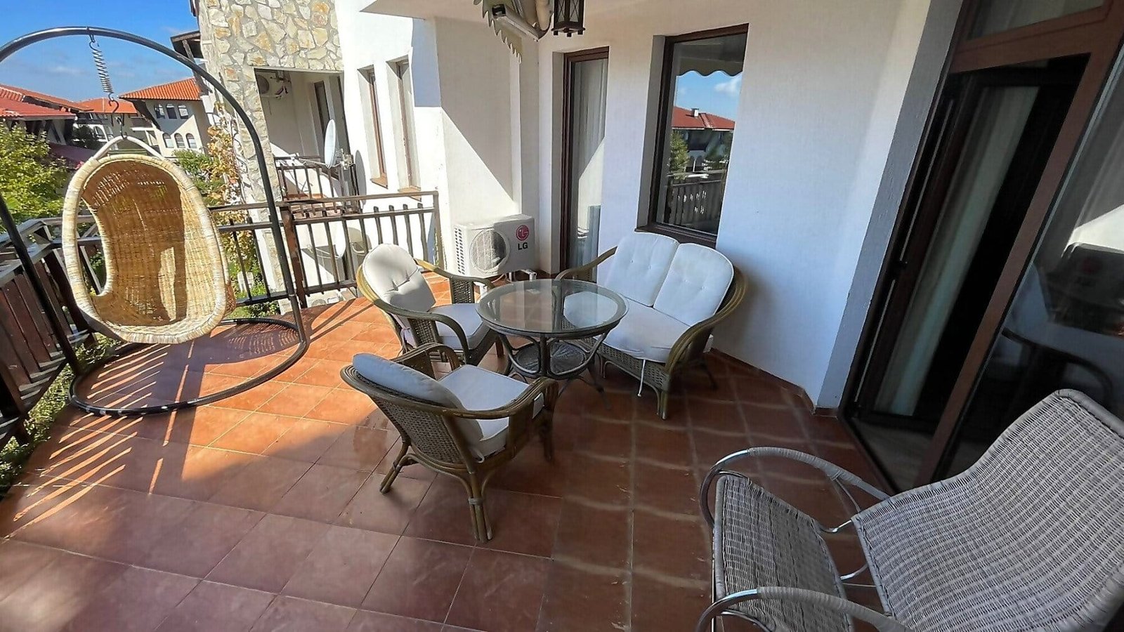 Уютная терраса с мебелью для отдыха, идеальное место для покупок недвижимости в Болгарии. Теплые тона, зеленые виды.