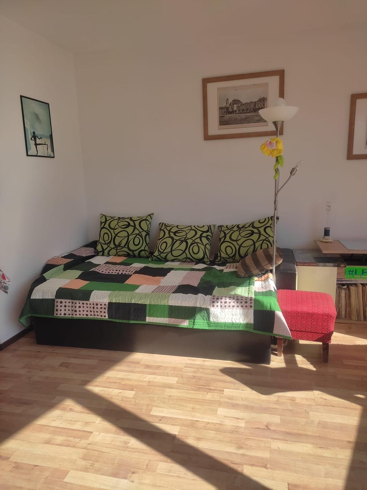 Современный интерьер квартиры в Болгарии с диваном, яркими подушками и деревянным полом, идеально подходящий для продажи.