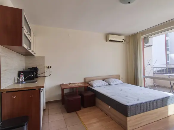 Современная студия с kitchenette, двуспальной кроватью и балконом, идеальная для жизни или аренды в Болгарии.