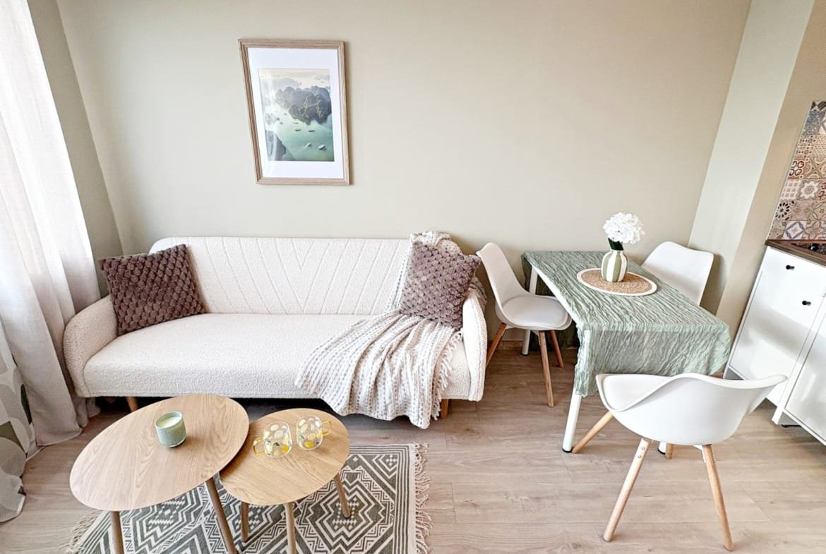 Современный интерьер с уютным диваном, столом и стульями, идеальный для продажи и покупки недвижимости в Болгарии.