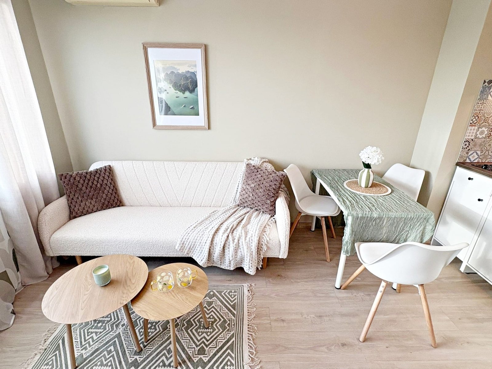 Современный интерьер с уютным диваном, столом и стульями, идеальный для продажи и покупки недвижимости в Болгарии.