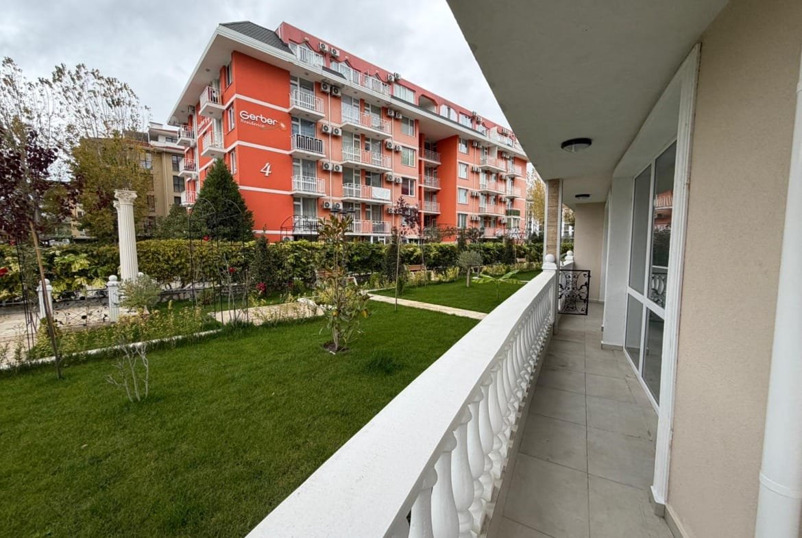 Современный многоквартирный дом в Болгарии с зеленым двором и ухоженной территорией, идеален для продажи и покупки недвижимости.