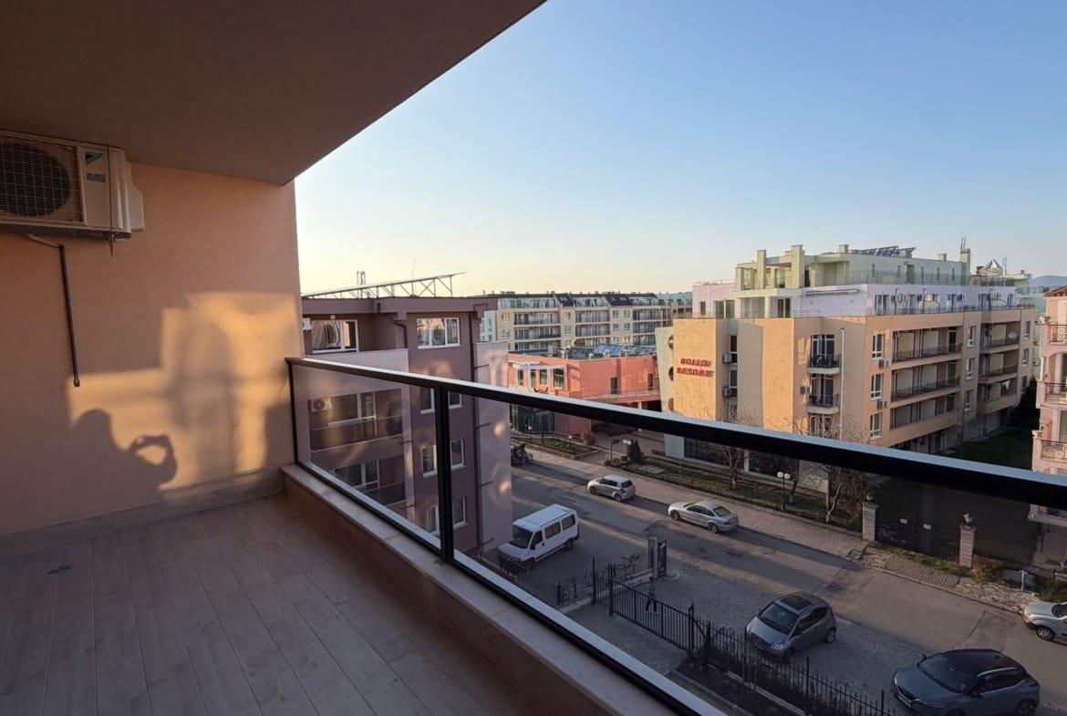 Балкон с видом на жилые здания и улицу в Болгарии, идеально подходит для покупки недвижимости у моря.