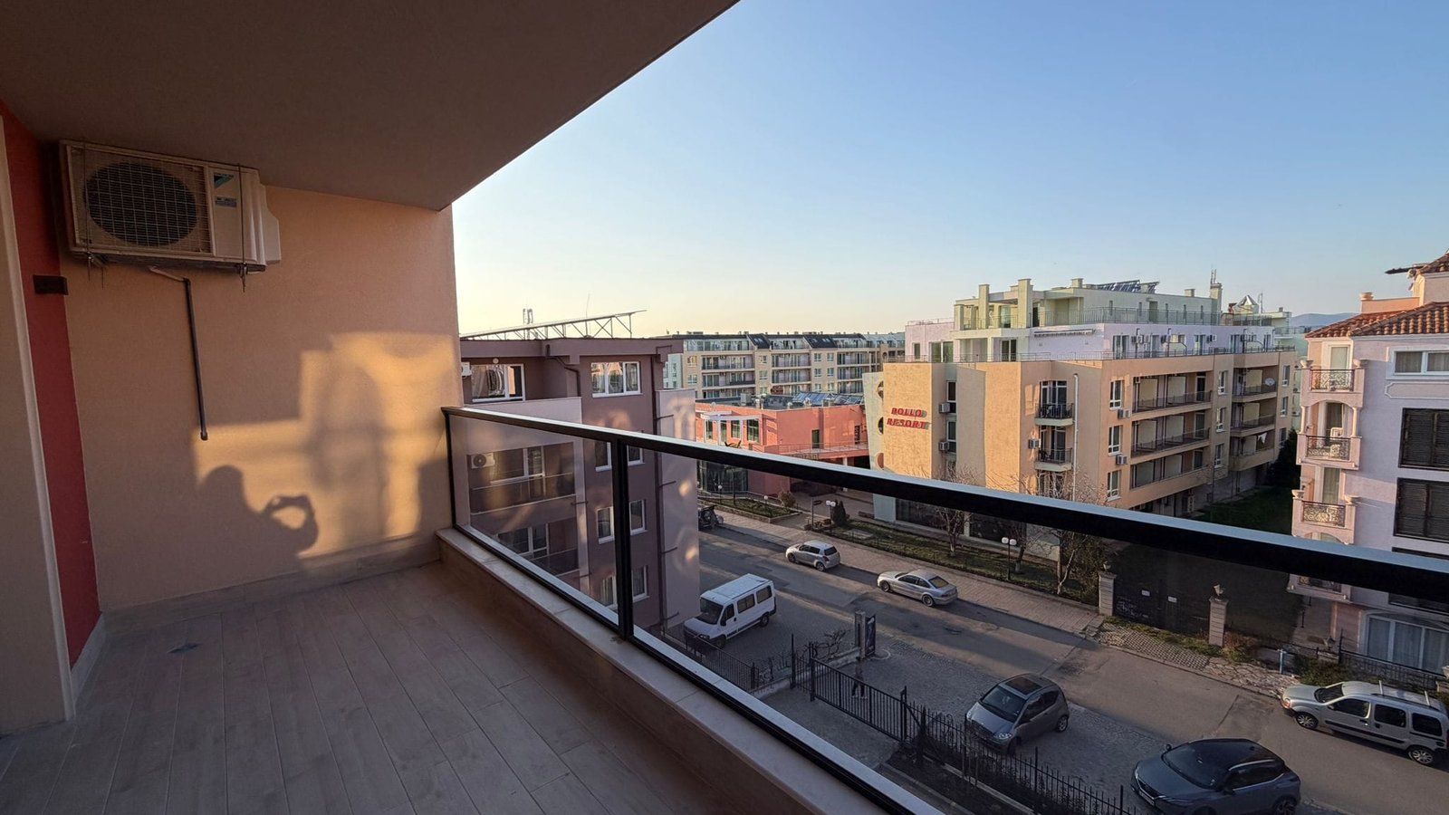 Современный балкон с видом на город в солнечный день Балкон с видом на жилые здания и улицу в Болгарии, идеально подходит для покупки недвижимости у моря.