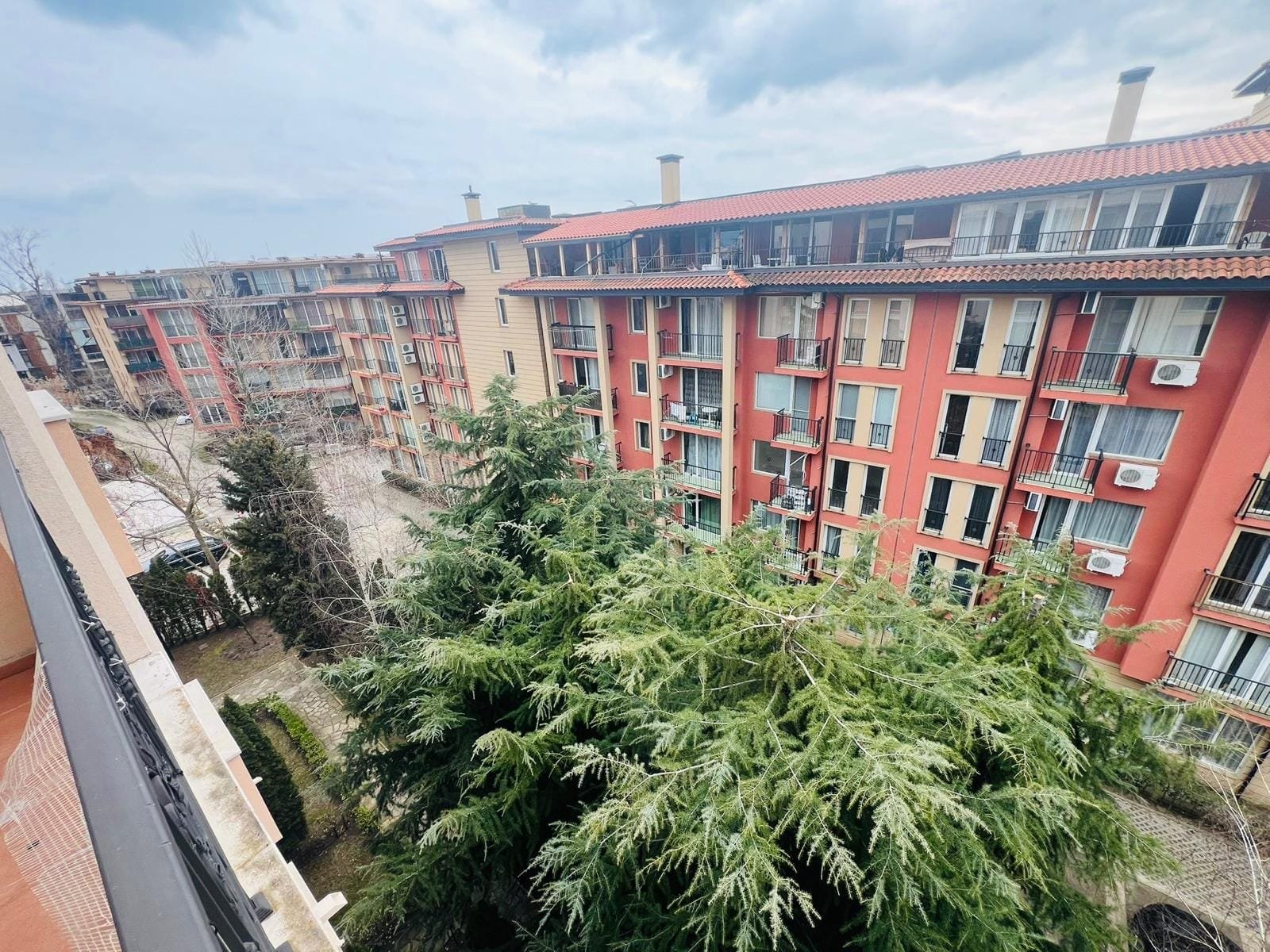 Современные жилые комплексы в Болгарии с зелеными насаждениями на фоне городской архитектуры.