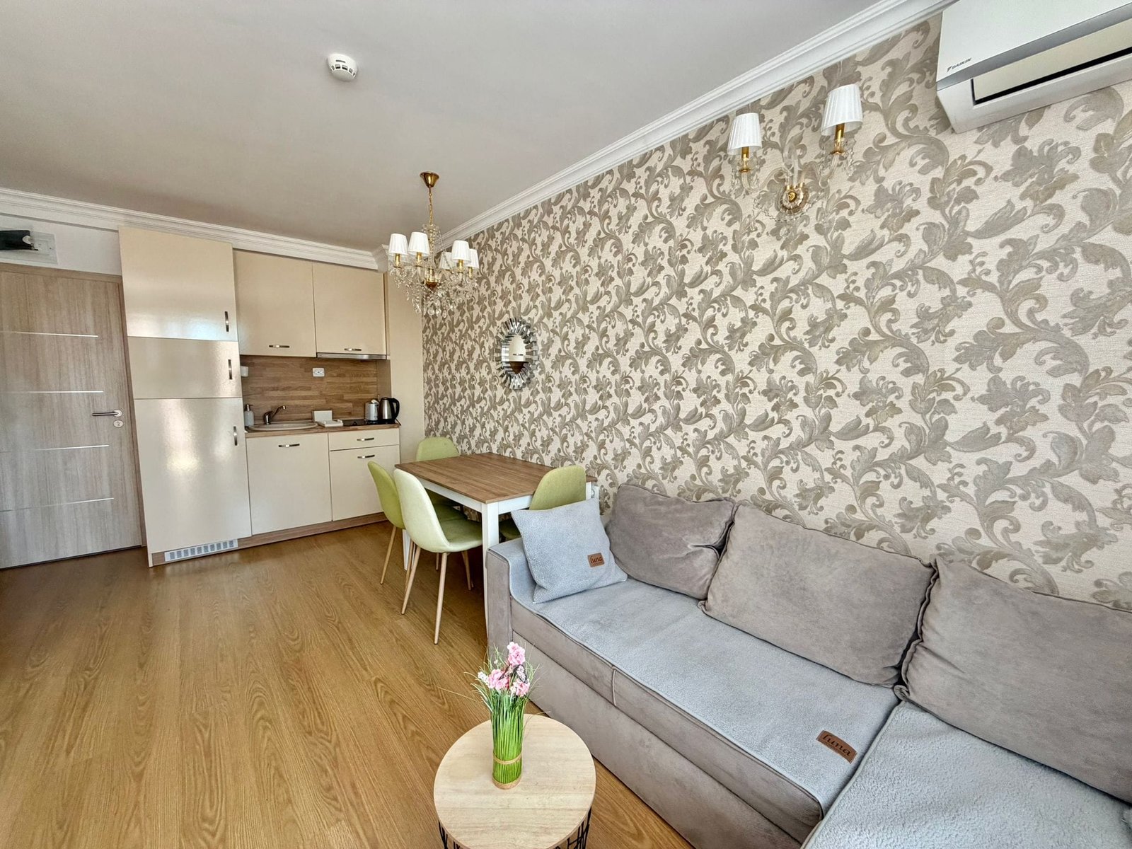 Современная квартира в Болгарии с уютной гостиной, кухней и обеденным столом, оформленная в светлых тонах.