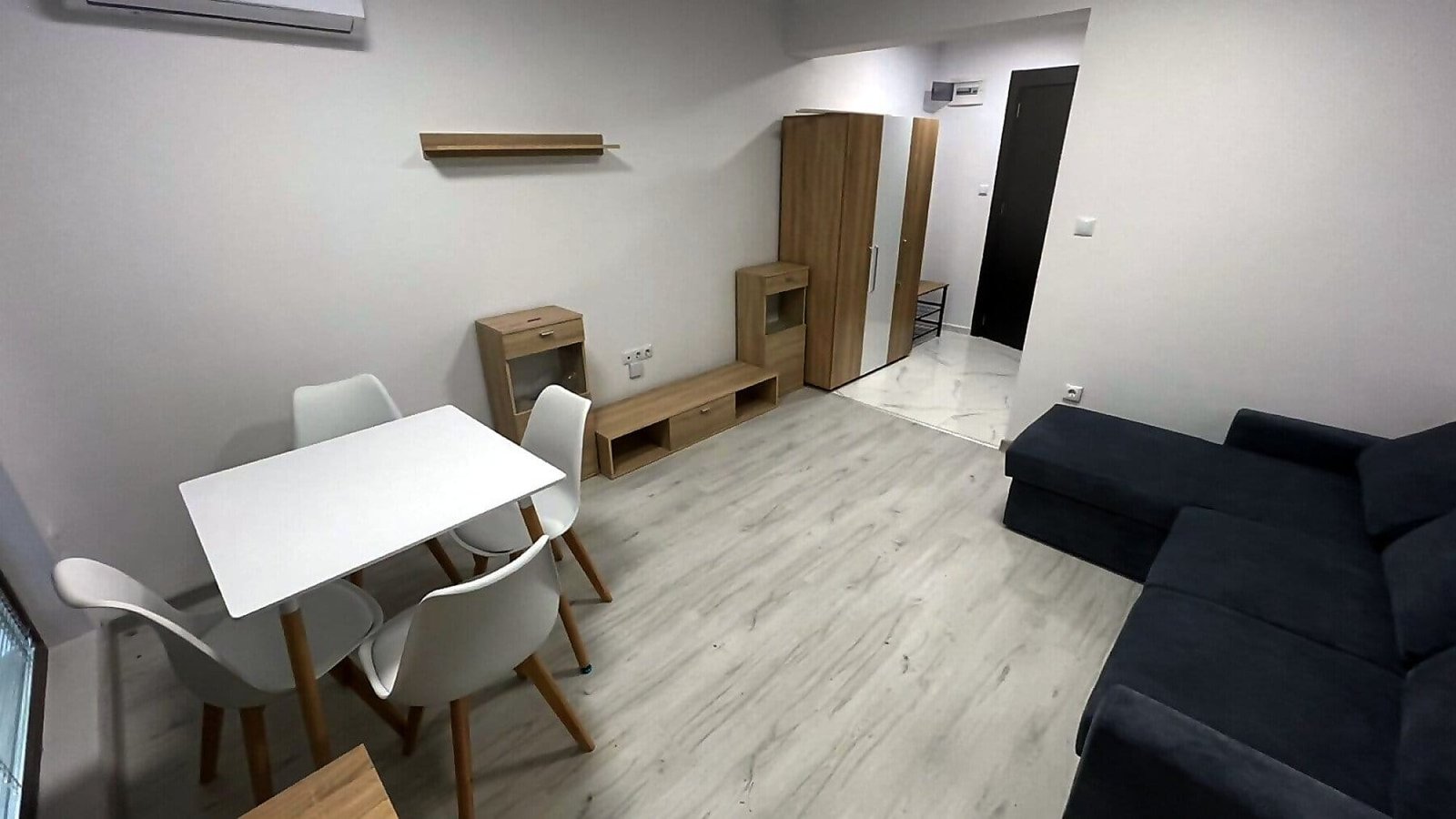 Современная квартира в Болгарии с уютной мебелью, обеденным столом и светлой отделкой, готовая для продажи или аренды.